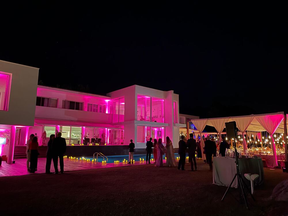 Villa iluminada en rosa durante un evento nocturno al aire libre